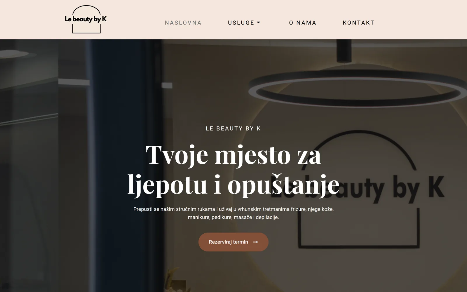 Izrada web stranice Le Beauty by K: naslovnica s interijerom salona, logotipom na zidu i gumbom za rezervaciju termina